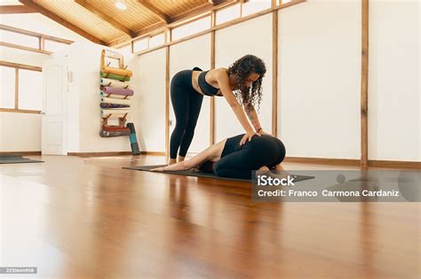 Yoga Teacher Assisting Student